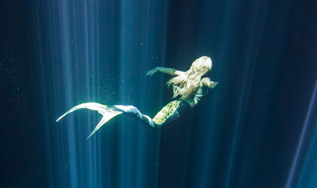 Frau mit Meerjungfrau-Kostüm unter Wasser